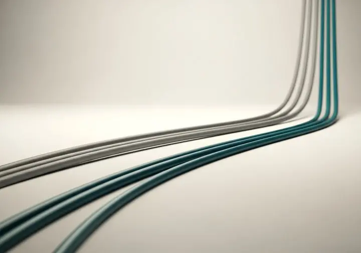 Grey and teal cables curving across a plain pale background